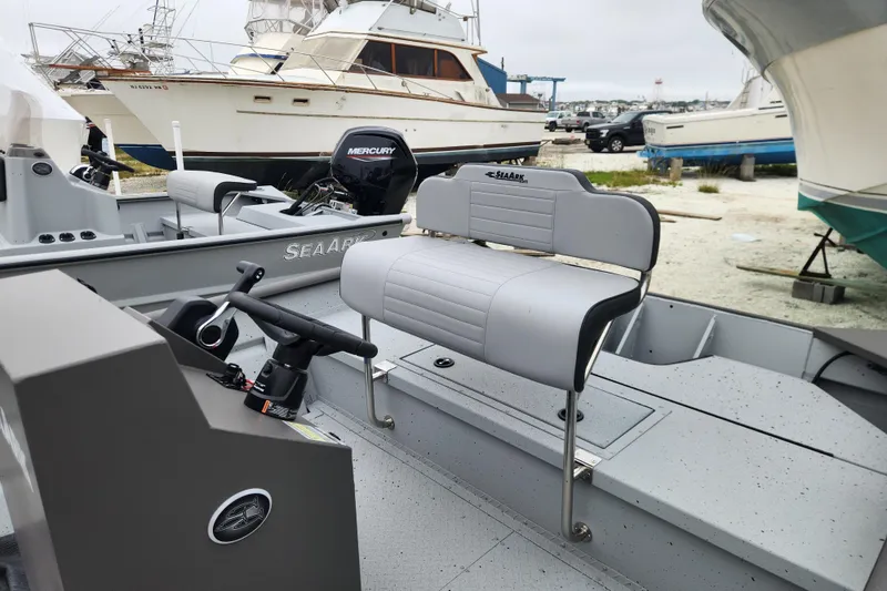 Slide: The Image of 2025 SeaArk 2072 Workhorse boat with Mercury engine, docked near other vessels. - 5