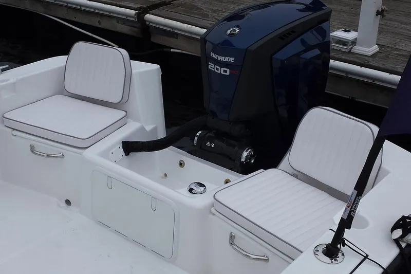 Slide: The Image of 2026 Maritime 233 Defiant boat dashboard with steering wheel and controls in a garage setting. - 10