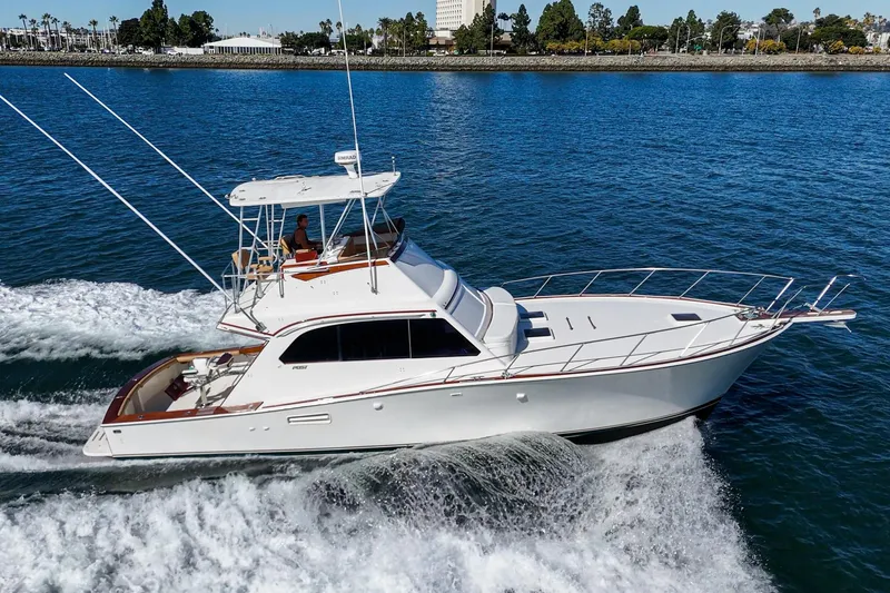 Slide: The Image of 1984 Post 43 yacht cruising on blue water near a scenic shoreline. - 10