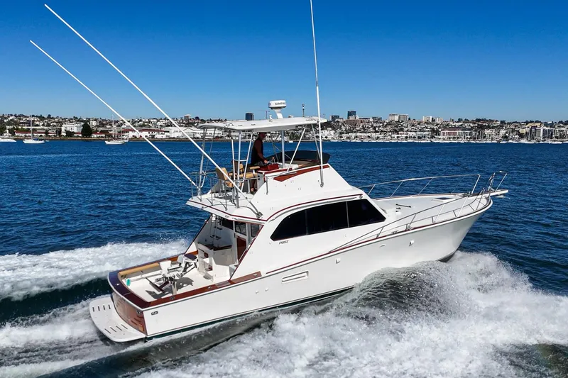 Slide: The Image of 1984 Post 43 yacht cruising on blue water with cityscape in the background. - 11