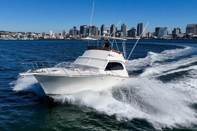 Slide: The Image of 1984 Post 43 yacht cruising on water with city skyline in background. - 15