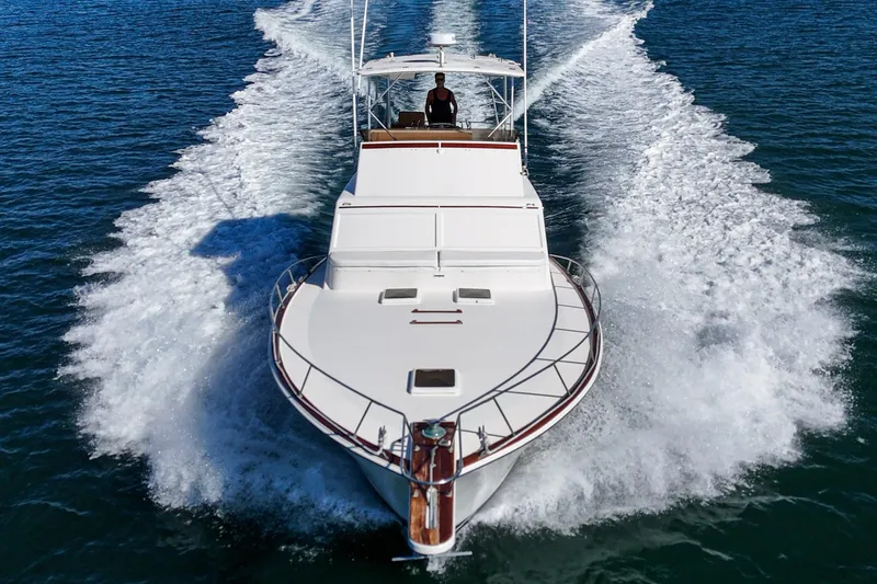 Slide: The Image of 1984 Post 43 yacht cruising on open water, creating a dynamic wake. - 16