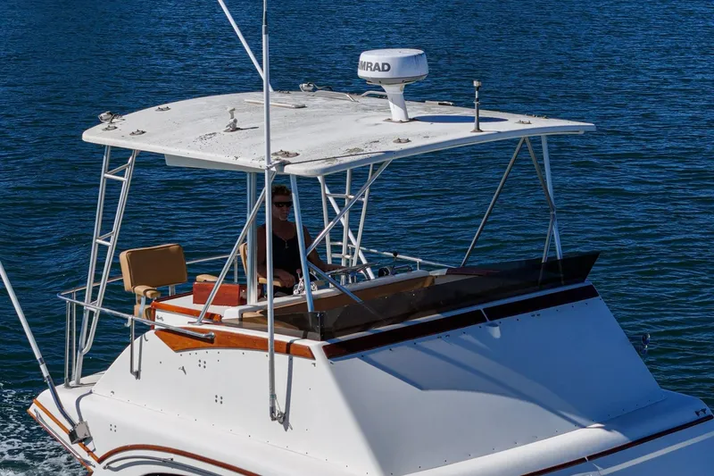 Slide: The Image of 1984 Post 43 boat cruising on blue water with a person at the helm. - 21