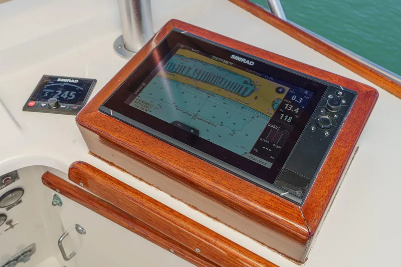 Slide: The Image of Simrad navigation system on 1984 Post 43 boat, featuring a wooden console. - 25