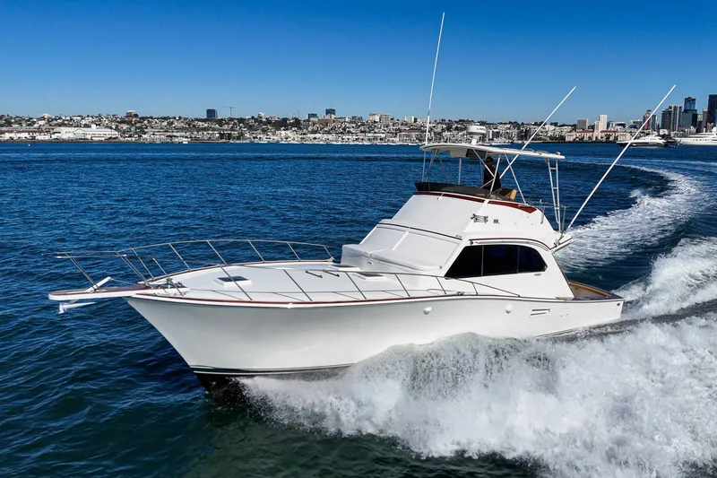 Slide: The Image of 1984 Post 43 yacht cruising on blue ocean near city skyline. - 3