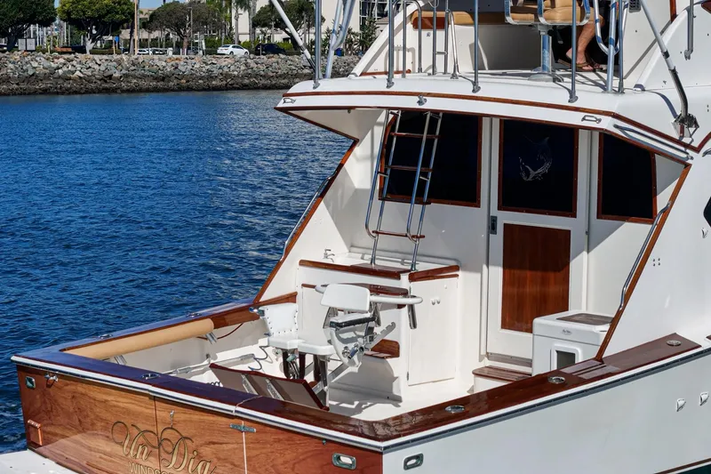 Slide: The Image of 1984 Post 43 yacht with wooden accents docked by a rocky shoreline. - 30