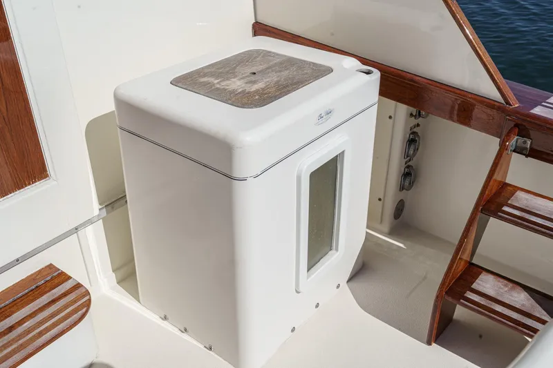 Slide: The Image of White marine icebox on a 1984 Post 43 boat deck with wooden accents. - 33