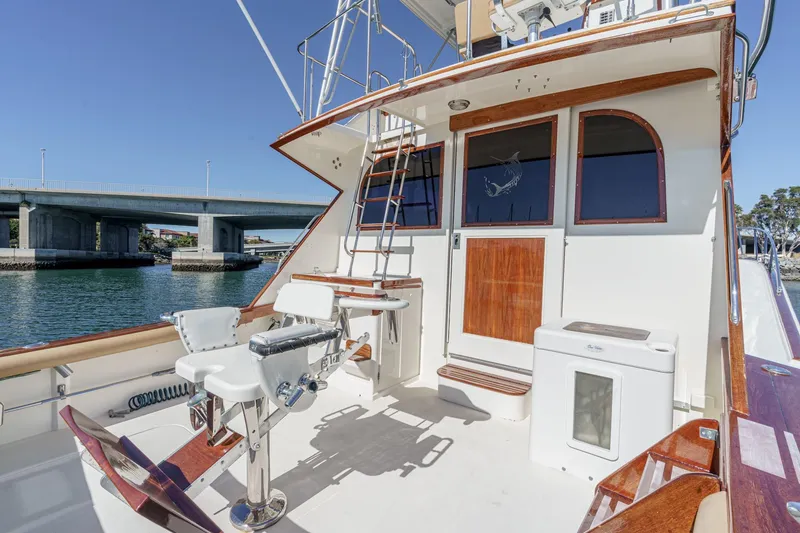 Slide: The Image of 1984 Post 43 yacht deck with fishing chairs, ladder, and scenic waterway view. - 35
