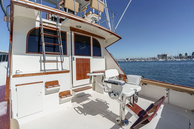 Slide: The Image of 1984 Post 43 yacht deck with fishing chairs, ladder, and marina view. - 36