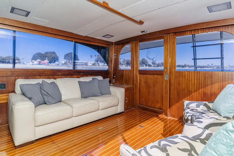 Slide: The Image of Luxurious yacht interior with wooden paneling, cream sofa, and large windows offering scenic views. - 47