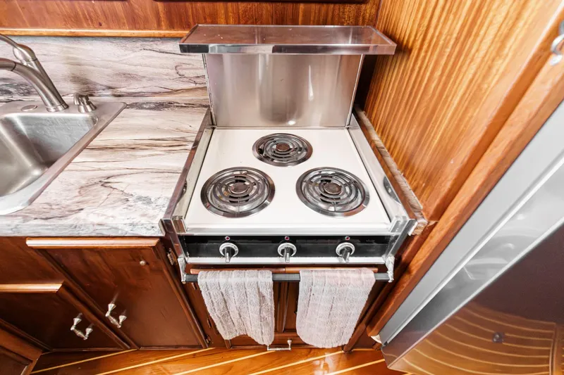 Slide: The Image of Compact kitchen with electric stove, marble countertop, and wooden cabinetry in a 1984 Post 43 model. - 52