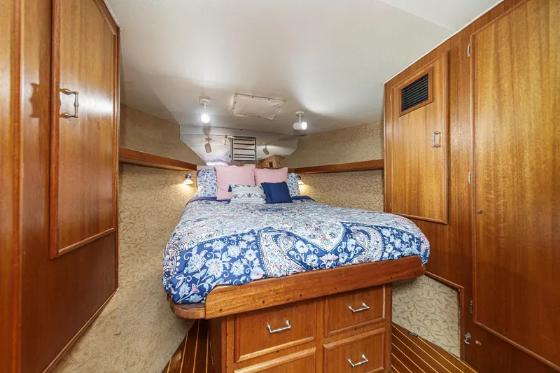 Slide: The Image of Cozy cabin interior of 1984 Post 43 yacht with wooden furnishings and patterned bedding. - 55