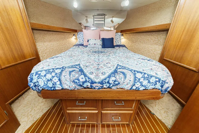 Slide: The Image of Cozy bedroom in 1984 Post 43 boat with patterned bedding and wooden accents. - 56