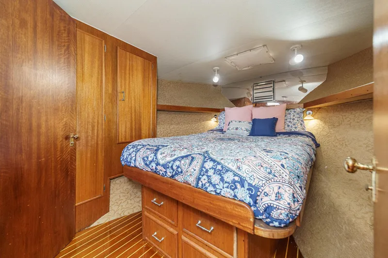 Slide: The Image of Cozy bedroom in 1984 Post 43 boat with wooden cabinets and patterned bedding. - 57