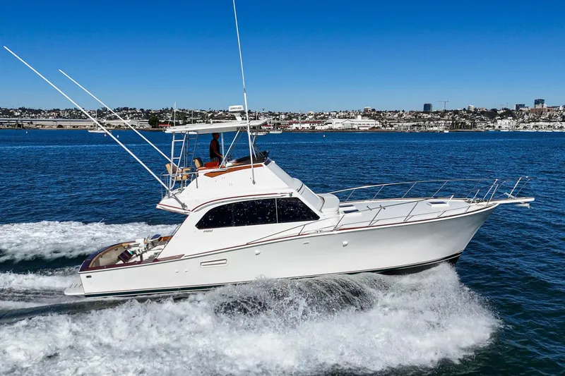 Slide: The Image of 1984 Post 43 yacht cruising on blue water with cityscape background. - 6