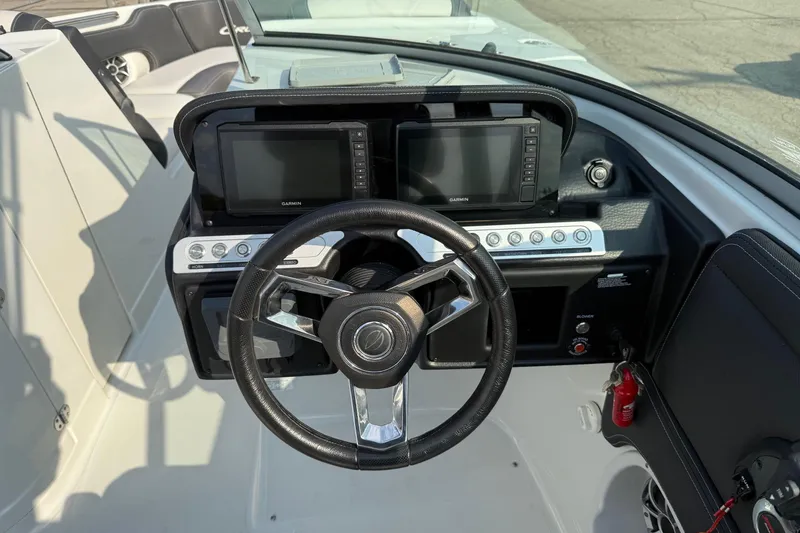Slide: The Image of 2023 Crownline 260 SS boat dashboard with steering wheel and dual Garmin displays. - 11