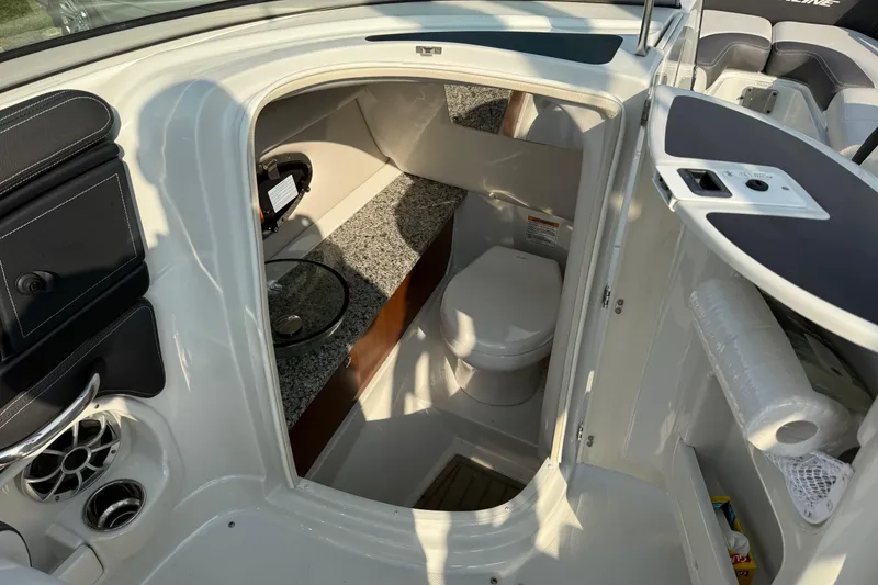 Slide: The Image of 2023 Crownline 260 SS boat interior with compact bathroom and modern amenities. - 9