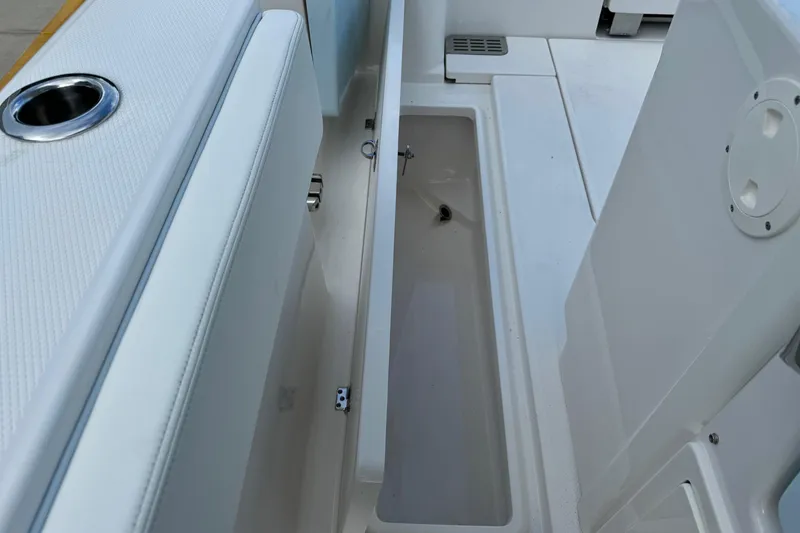 Slide: The Image of 2025 Robalo R360 Center Console boat storage compartment with cup holder. - 17