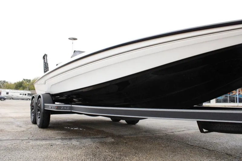 Slide: The Image of 2026 Skeeter ZXE21 boat on trailer, showcasing sleek design and dual-axle wheels. - 9