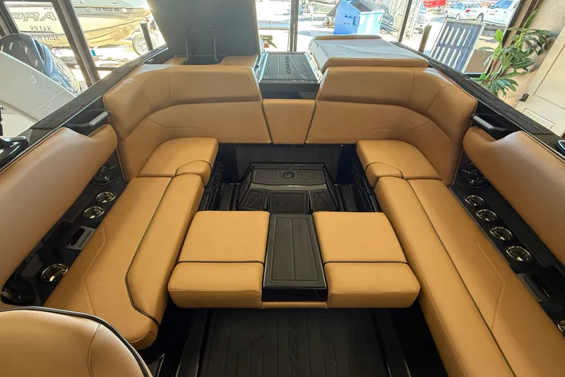 Slide: The Image of 2026 Moomba Max boat interior with tan seating and cup holders. - 12