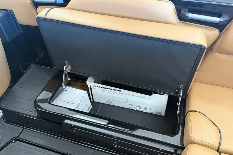 Slide: The Image of 2026 Moomba Max boat storage compartment with tan seats and mirror combo box. - 13
