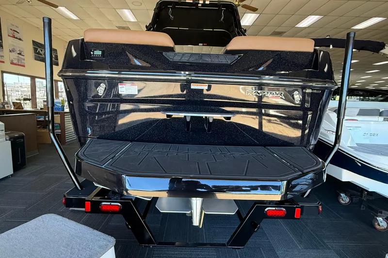 Slide: The Image of 2026 Moomba Max boat rear view in showroom, featuring Raptor engine branding. - 3