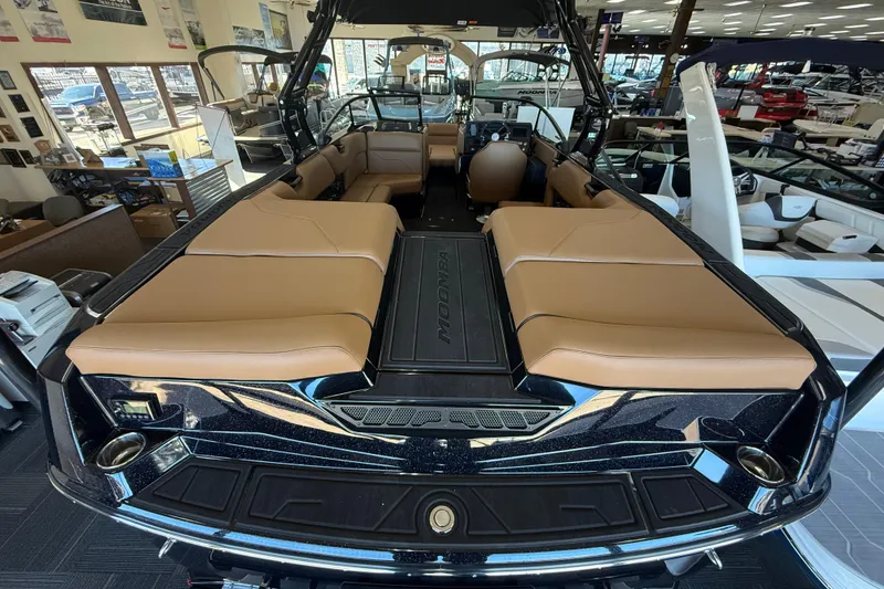 Slide: The Image of 2026 Moomba Max boat interior with tan seating and sleek design in showroom. - 5