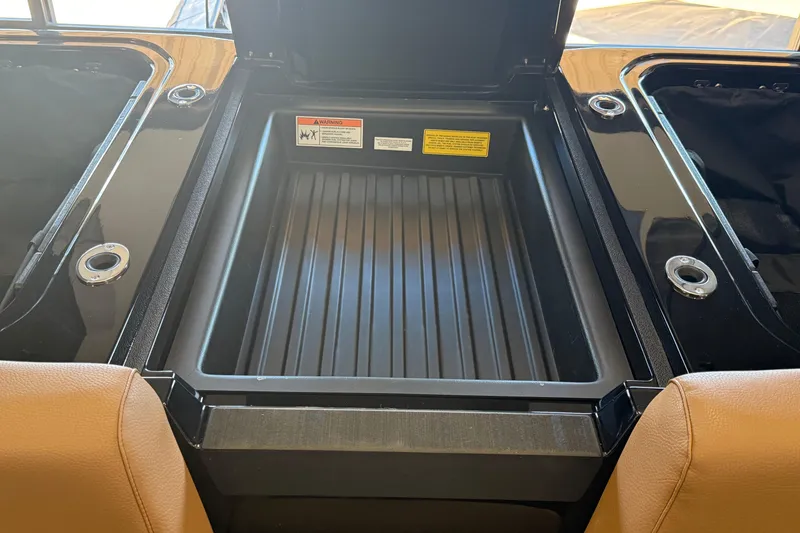 Slide: The Image of 2026 Moomba Max boat storage compartment with open lid and warning labels. - 8