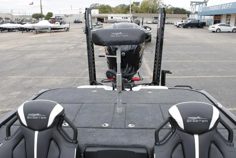 Slide: The Image of 2026 Skeeter ZXE20 boat interior with dual seats and motor in parking lot. - 13