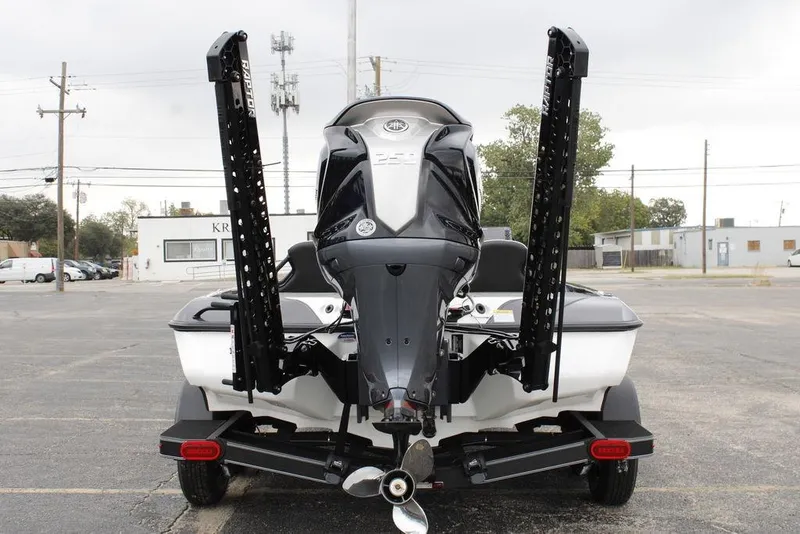 Slide: The Image of 2026 Skeeter ZXE20 boat rear view with motor and power poles in parking lot. - 8