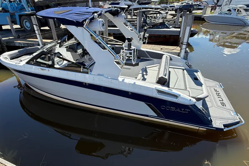Slide: The Image of 2021 Cobalt R6 Surf boat docked in marina, featuring sleek design and blue accents. - 3