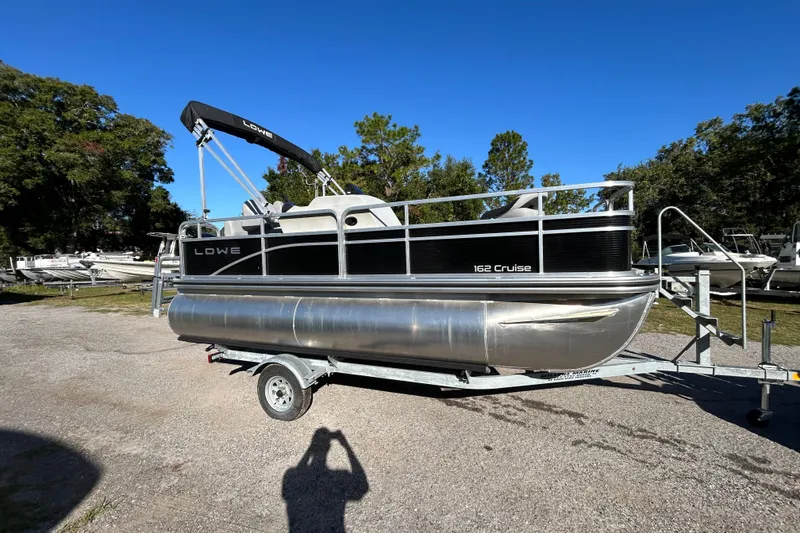 The Image of 2023 Lowe Ultra 162 Fish & Cruise pontoon boat on trailer, parked outdoors. - 12