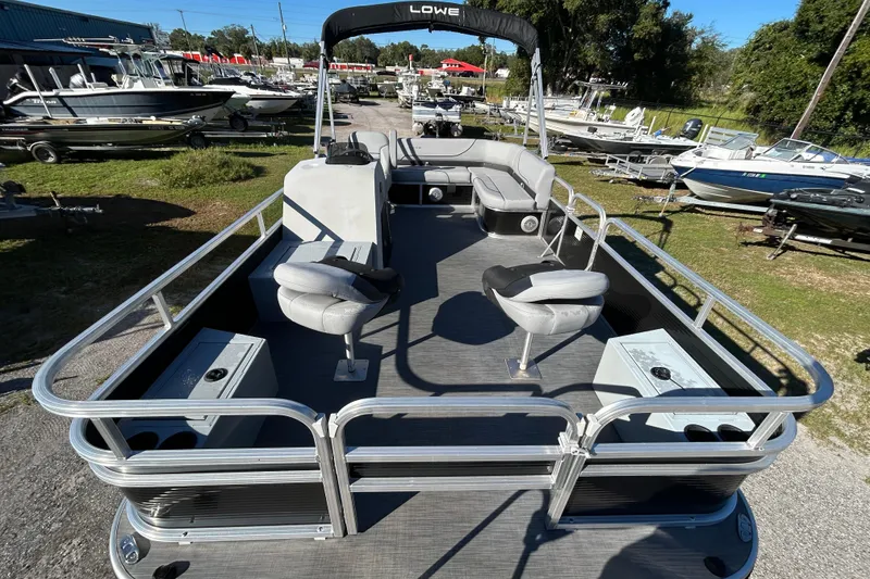 Slide: The Image of 2023 Lowe Ultra 162 Fish & Cruise pontoon boat with seating and helm, displayed outdoors. - 17