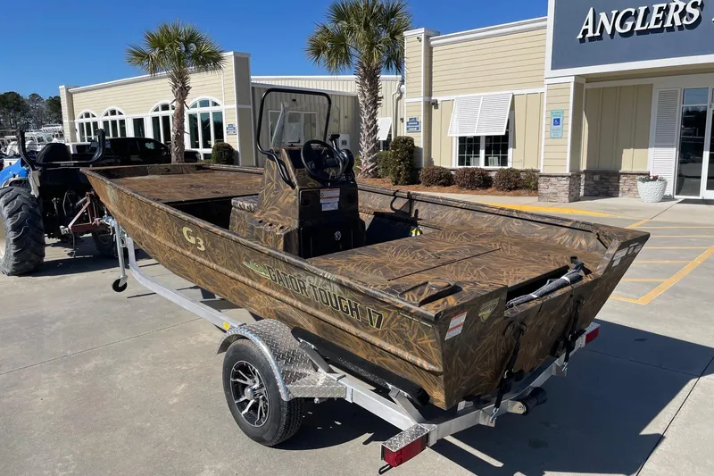 Slide: The Image of 2026 G3 17 CC Shadow Grass boat on trailer outside Anglers store. - 3
