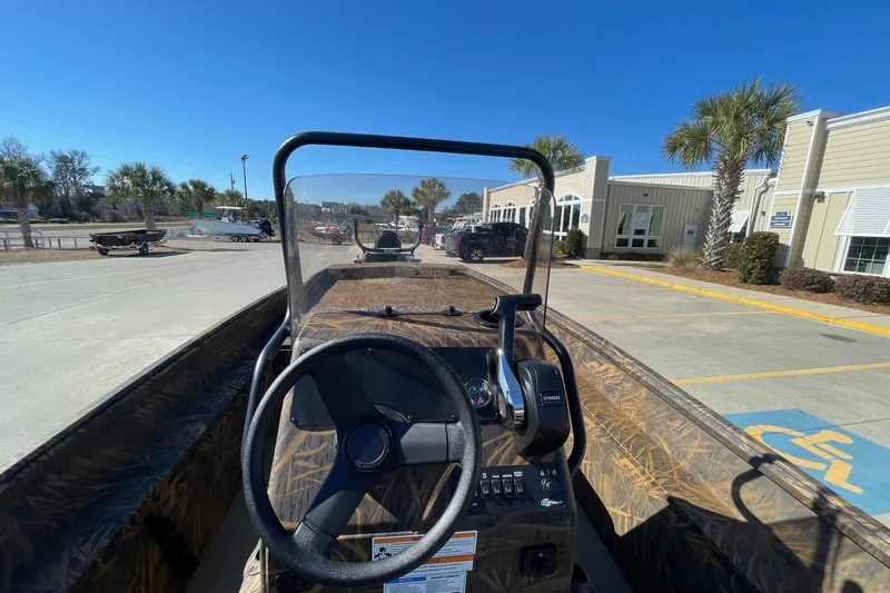 Slide: The Image of 2026 G3 17 CC Shadow Grass boat with steering wheel, parked outdoors near buildings. - 8