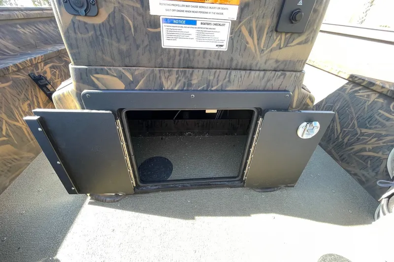 Slide: The Image of 2026 G3 17 CC Shadow Grass boat storage compartment with open doors, camo design. - 9