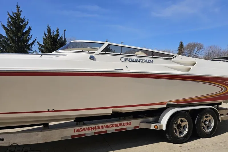 Slide: The Image of 2007 Fountain 35 Lightning speedboat on trailer, white with red accents, parked outdoors. - 22