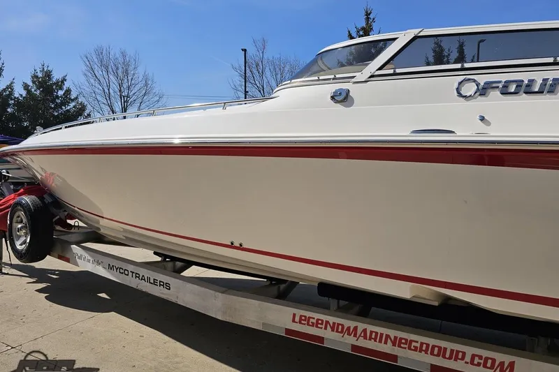Slide: The Image of 2007 Fountain 35 Lightning boat on trailer, white with red accents, clear sky background. - 24