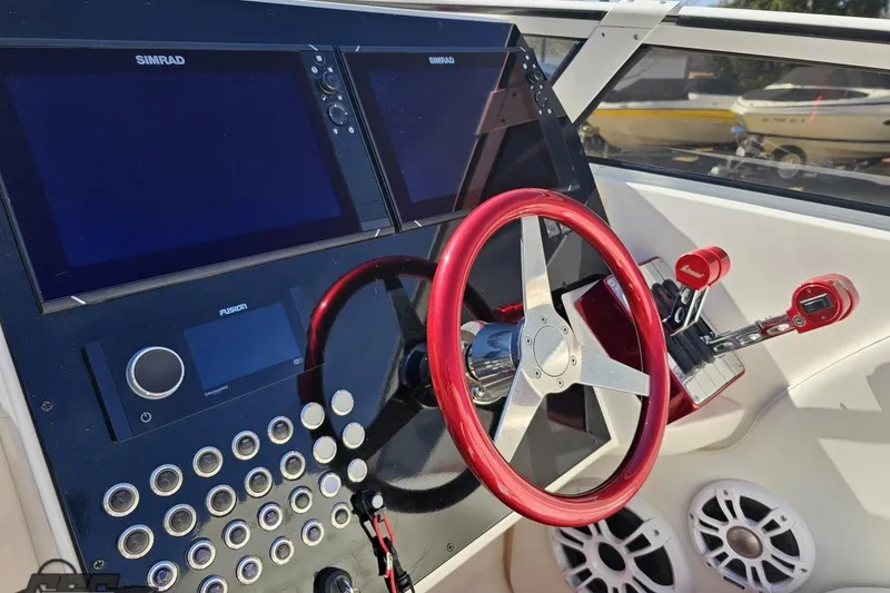 Slide: The Image of 2007 Fountain 35 Lightning boat dashboard with red steering wheel and advanced controls. - 64