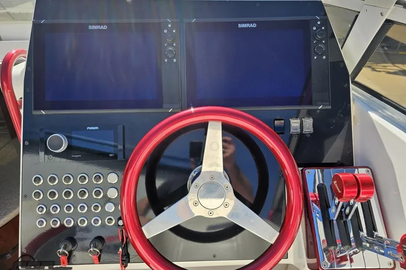 Slide: The Image of 2007 Fountain 35 Lightning boat dashboard with red steering wheel and dual Simrad displays. - 66