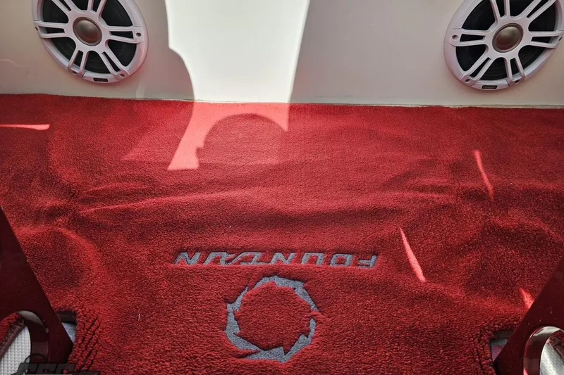 Slide: The Image of Red carpet with "Fountain" logo, surrounded by speakers, in a 2007 Fountain 35 Lightning boat. - 89