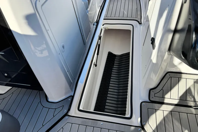 Slide: The Image of 2022 Yamaha Boats 212SE interior storage compartment with sleek design and non-slip flooring. - 18