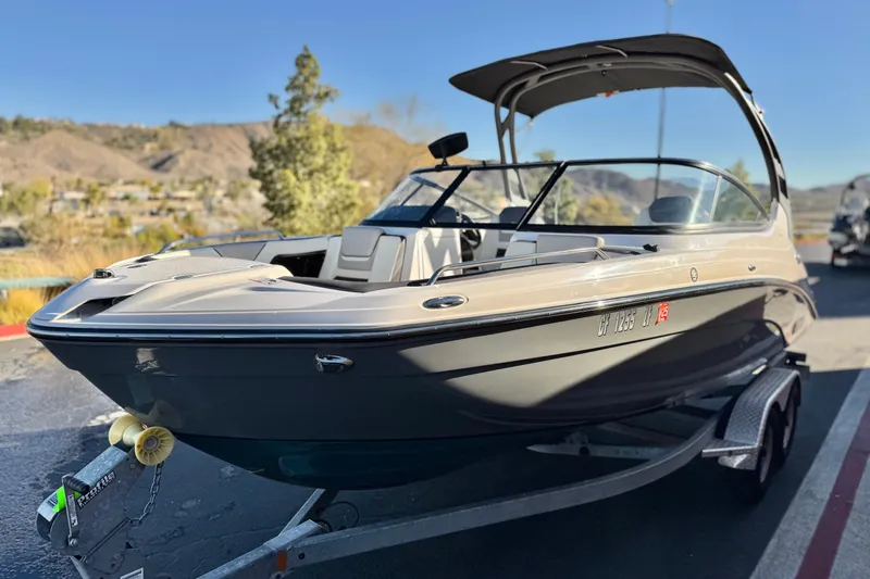 Slide: The Image of 2022 Yamaha Boats 212SE on trailer, parked outdoors with scenic background. - 3