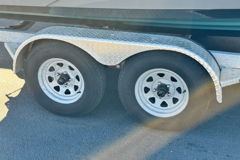 Slide: The Image of Trailer wheels of a 2022 Yamaha Boats 212SE, featuring diamond plate fenders. - 34