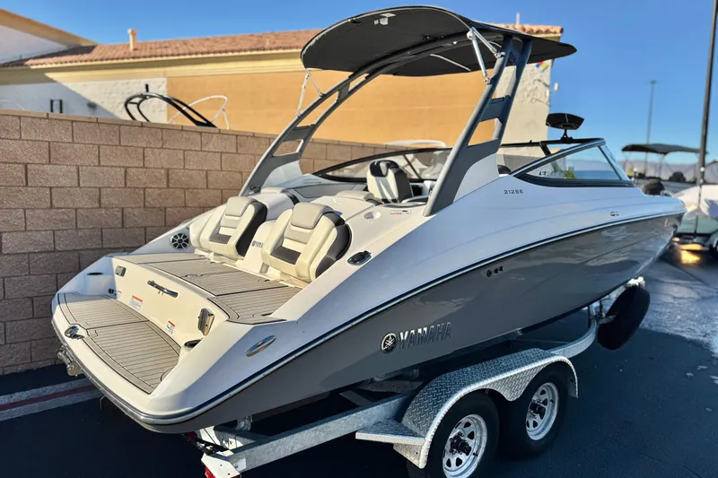 Slide: The Image of 2022 Yamaha Boats 212SE on trailer, sleek design, dual seating, outdoor setting. - 5
