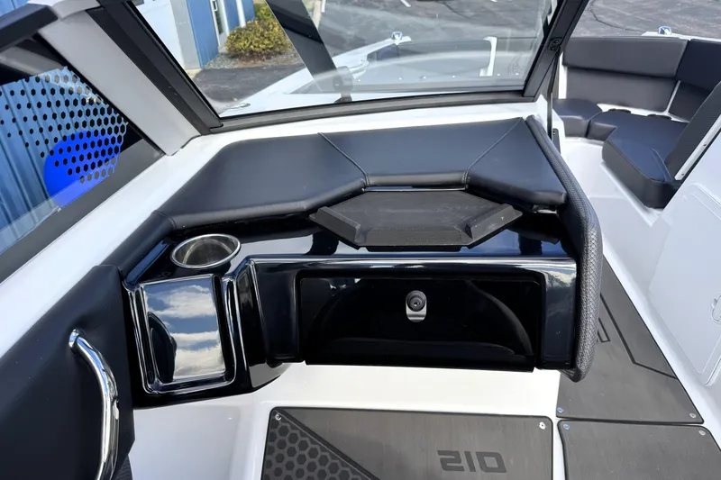 Slide: The Image of 2026 Scarab 210 LX boat interior with sleek black and white design, cup holder, and seating. - 15