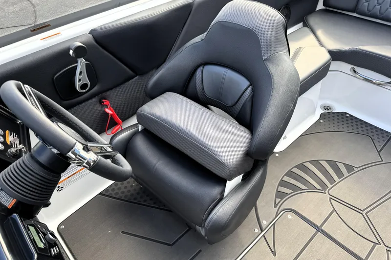Slide: The Image of 2026 Scarab 210 LX boat interior with black captain's seat and steering wheel. - 20