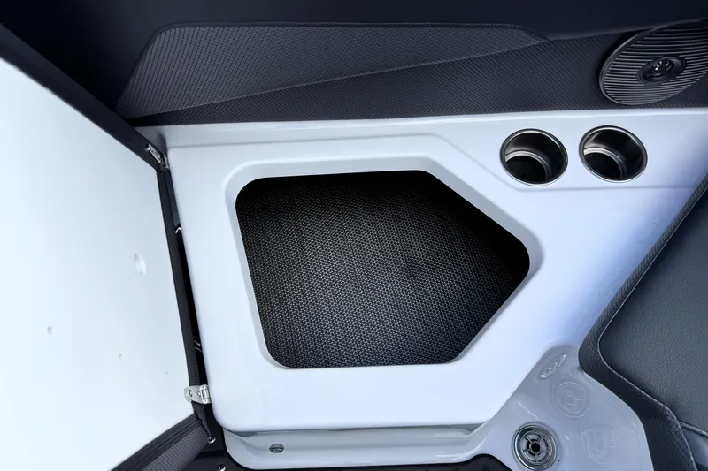 Slide: The Image of Interior detail of 2026 Scarab 210 LX boat, featuring storage compartment and cup holders. - 22