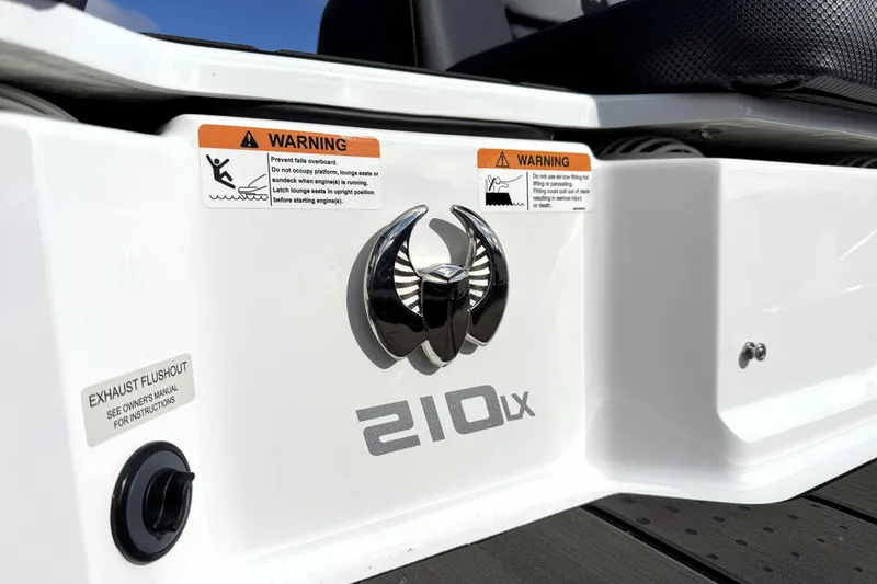 Slide: The Image of 2026 Scarab 210 LX boat stern with warning labels and exhaust flushout. - 27