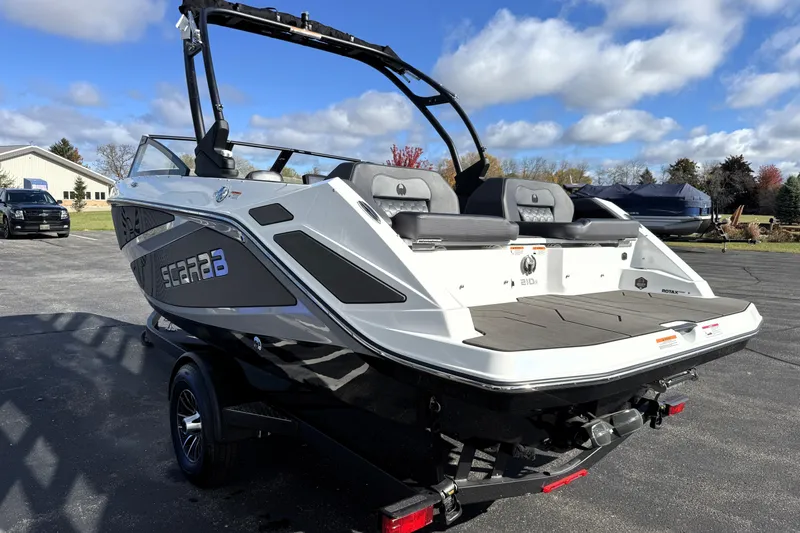 Slide: The Image of 2026 Scarab 210 LX boat on trailer, parked outdoors under a blue sky. - 3